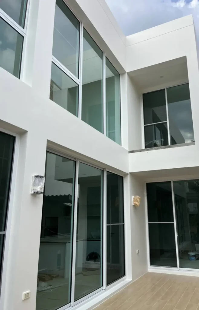 ประตูบานเลื่อนอลูมิเนียมกรอบขาว TOSTEM ATIS ติดตั้งรอบเฉลียงบ้านโมเดิร์นสองชั้น
