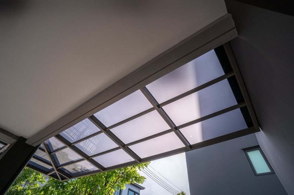 หลังคาอะคริลิค ShinkoLite Heat Cut G828 สีเทาฝ้า มุมมองจากใต้หลังคาบริเวณทางเดินข้างบ้าน